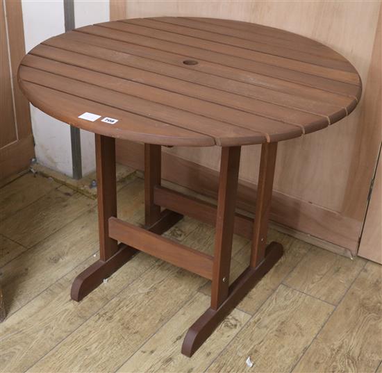 A teak circular topped garden table W.90cm